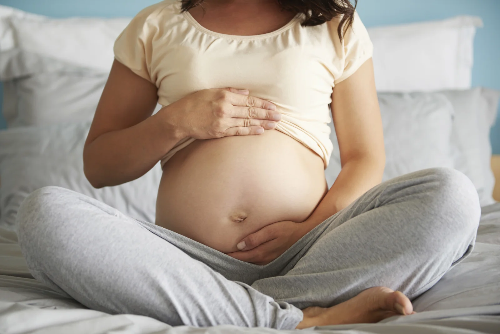 Gestante acolhendo a barriga com as mãos